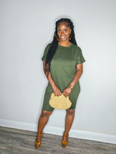 Load image into Gallery viewer, Woman wearing a dark olive 2 piece set standing against a white wall with a straw purse.